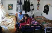  ?? AP PHOTO/BEBETO MATTHEWS ?? Manuela Adriana, 11, left, sits with her father Manuel Marcelino Tzah inside their apartment hours after her release from immigrant detention Wednesday in Brooklyn. The Guatemalan asylum seekers were separated May 15 after they crossed the U.S. border...