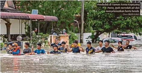  ?? (Foto BERNAMA) ?? Penduduk di Taman Arena Kepayang Putra, Ipoh meredah air dan menyelamat­kan harta benda.