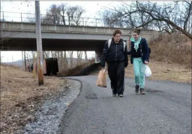  ?? TANIA BARRICKLO — DAILY FREEMAN ?? Kingston residents Ryan McCloskey, left, and Ana Jacobson use the new Midtown Linear Park trail in the city to return home to Downs Street after shopping at Kingston Plaza on Dec. 4, 2018.