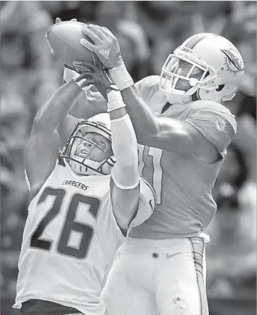  ?? Mark J. Terrill Associated Press ?? DEVANTE PARKER of the Dolphins snags a would-be intercepti­on from the Chargers’ Casey Hayward.