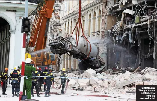  ?? ?? CARNAGE: The gas tanker is lifted away from the wrecked hotel