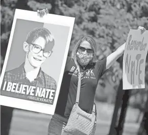  ?? SARAH KLOEPPING/USA TODAY NETWORK-WISCONSIN ?? Melissa Samuels, a friend of Nate Lindstrom and Green Bay resident, protests on June 6 along Webster Avenue outside St. Norbert Abbey at the De Pere-Allouez border. Lindstrom, 45, said three priests sexually abused him as a teen; he died by suicide in March.