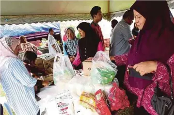  ??  ?? PENDUDUK membeli barangan keperluan harian sempena program jualan rakyat Parlimen Pokok Sena, semalam.