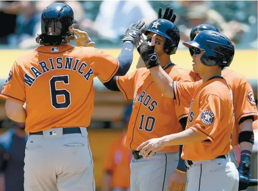  ?? PHOTO AFP ?? Jake Marisnick est félicité par ses coéquipier­s après avoir frappé un coup de circuit de trois points, hier, face aux A's d’Oakland.