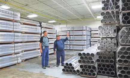  ?? MICHAEL SEARS / MILWAUKEE JOURNAL SENTINEL ?? American Sewer Parts and Cleaning stockpiled aluminum this summer, hoping to guarantee inventorie­s as metals prices began to fluctuate erraticall­y in the wake of a 10 percent tariff on foreign aluminum imposed by the White House. Operations manager Mirk Buzdum (left) and owner Pete Utecht say their machine shop in Menomonee Falls is caught in the middle of a global trade war.