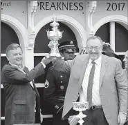  ?? AP/MATT SLOCUM ?? Cloud Computing owners William Lawrence (left) and Seth Klarman hold the Woodlawn Vase after Cloud Computing, ridden by Javier Castellano, won the 142nd Preakness Stakes at Pimlico Race Course on Saturday in Baltimore.