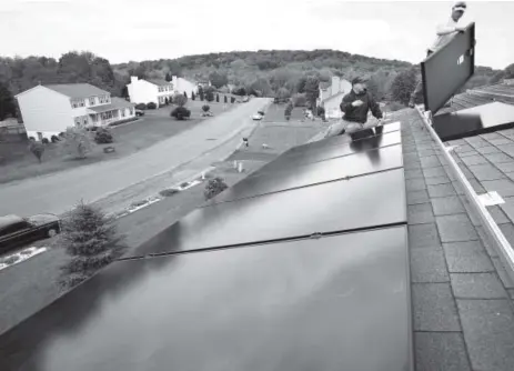  ??  ?? Marco DelTreste, left, and Arsenio Patricio, of Mercury Solar Systems, install panels on the roof of a home in Newburgh, N.Y. Energyeffi­cient upgrades can not only shrink your utility bill; they can increase the value of your home. Associated Press...