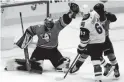  ?? AP ?? Ducks goaltender Ryan Miller makes a save vs. the Coyotes’ Lawson Crouse, right, who collides with Jamie Drysdale during Thursday’s game in Anaheim.