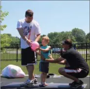  ?? KHADIJA SMITH — THE MORNING JOURNAL ?? Jason Brown and his 4-year-old son, Liam Brown enjoy exercising outdoors with the help of Ryan Ladd, program director, on June 11 during the “Dumbbell with Dads” fitness class at Mercy Health and Recreation Center, 47160 Hollstein Drive in Amherst.