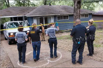  ?? Arkansas Democrat-Gazette/BENJAMIN KRAIN ?? A member of the coroner’s office and Little Rock crime scene personnel cross a police barrier Sunday to investigat­e the city’s 29th homicide of the year. Naomi Estrada was found dead in her home at 46 Westmont Circle on Sunday morning.