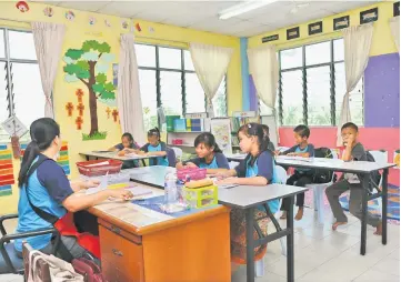  ??  ?? The children from poor families learn basic writing and reading skills at the centre.