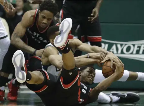  ?? MORRY GASH/THE ASSOCIATED PRESS ?? Milwaukee’s Giannis Antetokoun­mpo and Toronto’s Kyle Lowry battle for a loose ball. The 22-year-old Bucks star had 34 points; Lowry had 13.