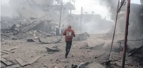  ?? FOTO: DPA ?? Ost-Ghuta liegt in Trümmern: Ein Mitarbeite­r der Organisati­on Syrischer Roter Halbmond geht durch ein Viertel der Stadt im syrischen Rebellenge­biet nahe Damaskus. Dort starben in weniger als 48 Stunden fast 200 Zivilisten, darunter Dutzende Frauen und...