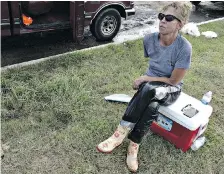  ?? BRIAN MELLEY, THE ASSOCIATED PRESS ?? Kelli Shofstall sits on an ice chest as she takes a break from her relief effort in Houston.