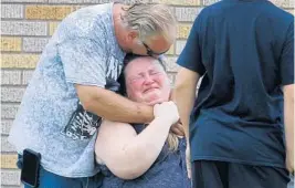  ?? MICHAEL CIAGLO/AP ?? A man hugs a woman outside a gym where parents were waiting to be reunited with their children following Friday morning’s attack.