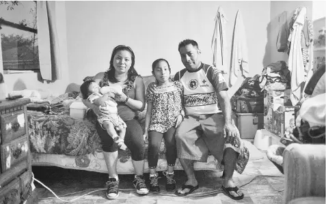  ??  ?? Sanchez, holding her son Gustavo, and Cirilo Perez pose for a portrait with their daughter Miriam, nine, on their bed in the main room of their trailer in Wimauma, Florida. Perez works in the local tomato fields, while Sanchez raises three-month-old...