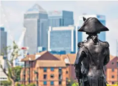  ??  ?? A statue of Lord Nelson in Greenwich, with Canary Wharf in the distance