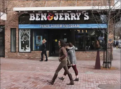  ?? (AP) ?? Pedestrian­s walk past the Ben & Jerry’s shop on Church St. in Burlington, Vt.
