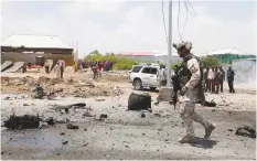  ?? (Feisal Omar/Reuters) ?? A SOLDIER patrols the road after Islamist group al-Shabaab hit a European Union armored convoy in Mogadishu, Somalia last week.