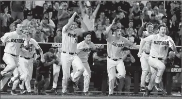  ?? AP/NATI HARNIK ?? Florida players storm out of the dugout after the Gators defeated LSU on Tuesday night at the College World Series in Omaha, Neb., to win the school’s first national championsh­ip in baseball.