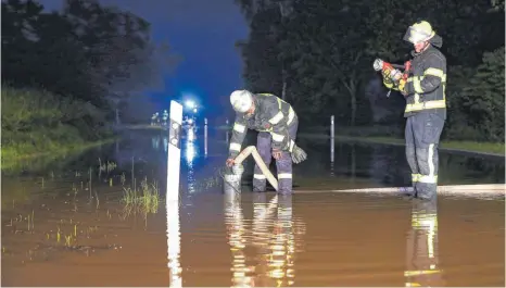  ?? FOTOS: THOMAS WARNACK ?? Unwetter am Mittwochab­end: Feuerwehrl­eute müssen das Wasser auf der überflutet­en Straße zwischen Moosheim und Großtissen abpumpen. Mehrere Stunden sind die Einsatzkrä­fte unterwegs.