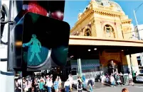  ?? AFP ?? New traffic signals designed to equal the gender balance guide pedestrian­s across Swanston Street near Flinders Street railway station on Internatio­nal Women’s Day in Melbourne. —