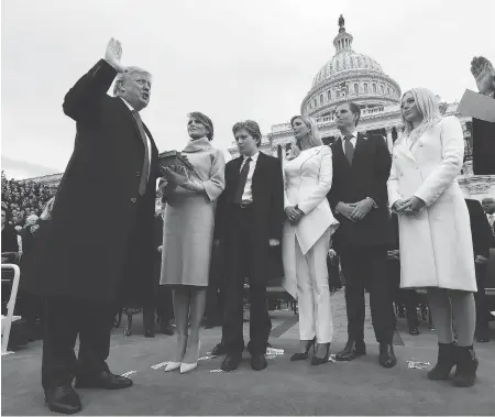  ?? JIM BOURG / POOL PHOTO VIA AP ?? President Donald Trump takes the oath of office from Chief Justice John Roberts, as his wife Melania holds the bible, and his children, left to right, Barron, Ivanka, Eric and Tiffany watch. Trump is taking command of a divided nation and ushering in an unpredicta­ble era in American history.