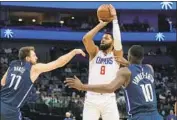  ?? LM Otero Associated Press ?? MARCUS MORRIS SR. shoots over the Mavericks’ Luka Doncic, left, and Dorian Finney-Smith.