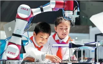  ?? ZHAI HUIYONG / FOR CHINA DAILY ?? Young visitors learn about a robot at an exhibition center in Haian, Jiangsu province.