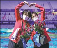  ?? REUTERS ?? China’s Chen Yuxi (left) and Quan Hongchan strike a pose after winning gold and silver respective­ly in the women’s 10m platform at the FINA World Championsh­ips in Budapest on Monday.