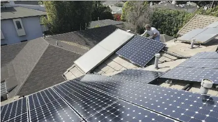  ?? GETTY IMAGES ?? A worker installs solar electric panels on a residentia­l rooftop in California. Last year, employment in the U.S. solar-energy business grew 12 times faster than overall job creation.