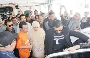  ??  ?? SHAFIE ditemani isterinya Datin Seri Shuryani Shuaib ketika diiringi pegawai SPRM masuk ke dalam kereta.