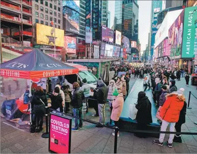  ?? WANG YING / XINHUA ?? People line up in New York City’s Times Square on Monday for COVID-19 tests. Omicron is now the dominant strain of the coronaviru­s in the United States, accounting for 73 percent of new infections last week.