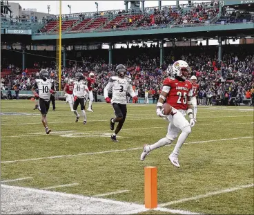  ?? WINSLOW TOWNSON / ASSOCIATED PRESS ?? Louisville’s Jawhar Jordan (right, 25) runs past Cincinnati’s Ja’von Hicks (3) for a touchdown during the first quarter of the Fenway Bowl NCAA game at Fenway Park, in Boston, on Dec. 17, 2022.