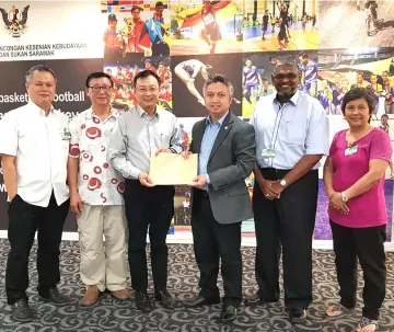  ??  ?? Snowdan (third left) receives letter of invitation to the event from the Mooncake Festival co-organising chairman Sim Kiang Chiok (fourth left).