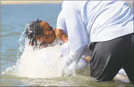  ??  ?? Sixteen-year-old Kevon High of Chesapeake Beach emerges from the Chesapeake Bay during his baptism. High and his mother, Mary, both got baptized at the Community Holy Baptism event in North Beach on Aug. 13.