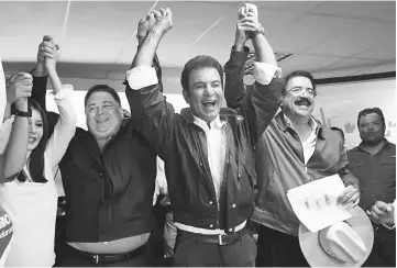  ??  ?? Salvador Nasralla (centre) gestures with Iroshka Elvir de Nasralla (left), Guillermo Valle (second left) and former president Manuel Zelaya (second right) after the general election in Tegucigalp­a. — AFP photo