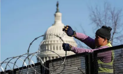  ??  ?? A worker removes razor wire from the top of security fencing on 20 March 2021, as part of a reduction in heightened security measures taken after the 6 January attack on the US Capitol in Washington DC. Photograph: Joshua Roberts/Reuters