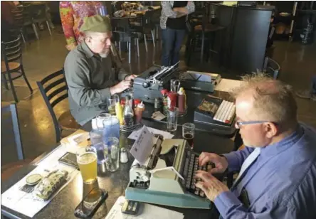  ?? RUSSELL CONTRERAS / THE ASSOCIATED PRESS ?? Joe Van Cleave, left, and Rich Boucher, right, try out various vintage typewriter­s at a “type-in” in Albuquerqu­e, N.M. “Type-ins” are social gatherings in public places where typewriter fans test different vintage machines.