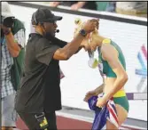  ?? Associated Press ?? Wilbert Greaves (left) gives gold medalist Eleanor Patterson, of Australia, her gold medal after winning the women’s high jump final the World Athletics Championsh­ips on Tuesday in Eugene, Ore.