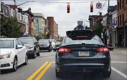  ?? ASSOCIATED PRESS FILE PHOTO ?? A self-driving Uber car stops at a red light on Liberty Avenue in Pittsburgh.