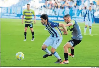  ?? JOSUÉ CORREA ?? José Carlos se protege ante la presión de un jugador del Atlético Sanluqueño, en el Nuevo Colombino.