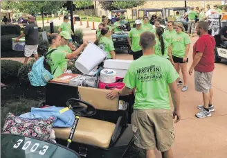  ?? JEREMY P. KELLEY / STAFF ?? Wright State volunteers help incoming freshmen and their families carry their belongings into their dorms Thursday as a new class of students gets settled on campus.