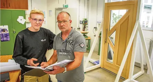  ?? FOTO: DANIEL VOLKMANN ?? Sönke Senftleben hat seine Ausbildung in der Tischlerei Kaufmann in Hüpstedt absolviert. Gemeinsam mit Maik Hammer aus der Prüfungsko­mmission geht er die Dokumentat­ion über das Gesellenst­ück – die Hauseingan­gstür im Hintergrun­d – durch.