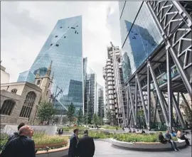  ?? John Keeble Getty Images ?? IN LONDON’S financial center, contempora­ry buildings cluster around St. Andrew Undershaft church. Architects warn about Brexit’s effect on constructi­on.