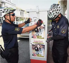  ??  ?? No go: Council workers taking down some of the posters at Lebuh Kimberly in George Town, Penang.