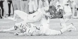  ?? Kim Brent / Beaumont Enterprise ?? McNeese State’s Kelvin Bennett (29) helps bring down Lamar’s Reggie Begelton during the unbeaten Cowboys’ Southland Conference victory in Beaumont.