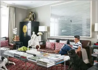  ?? DAVID A. LAND — VERN YIP VIA AP ?? This undated photo provided by interior designer Vern Yip shows Yip sitting on a couch with his dogs in his home in Atlanta. With progress in technology, durable rugs made with antimicrob­ial, stain-resistant fibers have become much more pleasant to the...