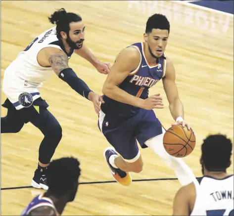  ?? ASSOCIATED PRESS ?? PHOENIX SUNS’ DEVIN BOOKER (1) drives the ball past Minnesota Timberwolv­es’ Ricky Rubio (9) in the first half of an NBA game on Sunday in Minneapoli­s.