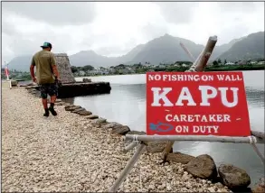  ?? AP/CALEB JONES ?? Fishpond researcher Luka Mossman walks along a pond in Kaneoho, Hawaii, last month. “You constantly watch how the natural system works, and you adapt to that,” he said about sustainabl­e aquacultur­e.